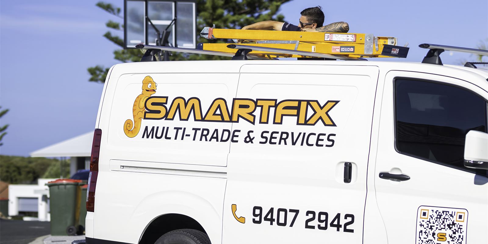 Smartfix van with Colin on the signage and a technician loading ladders on the roof